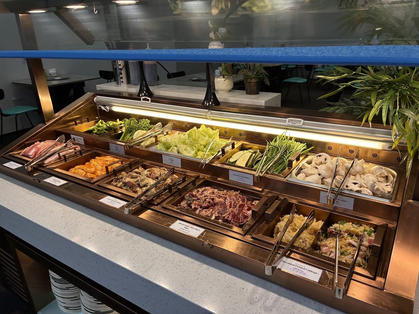 Raw BBQ meats and fresh vegetables counter